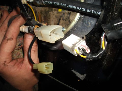 1989 Ford Probe - Disconnecting the electrical connector for the fuel pump assembly. A fuel hose marked SAE J30R9 is also visible in the frame.