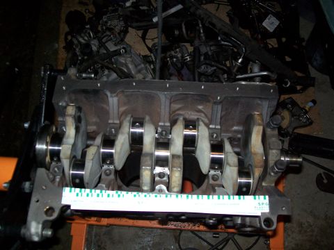 1989 Ford Probe - Engine block and crankshaft assembly, with a ruler for measurement. Other engine components are visible in the background.