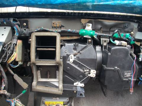 1989 Ford Probe - The interior of a car's dashboard is exposed, revealing the HVAC system and numerous wires.