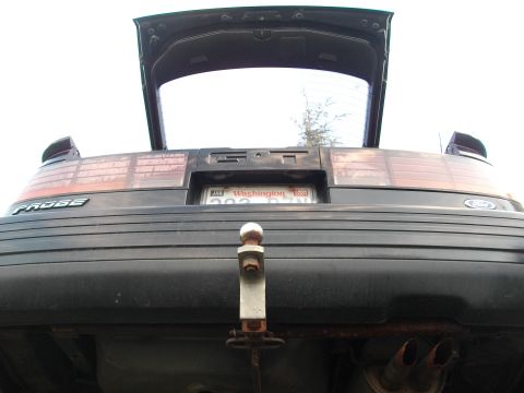 1989 Ford Probe - Rear view of a dark hatchback, identified by a 'PROBE' badge, with its trunk open.