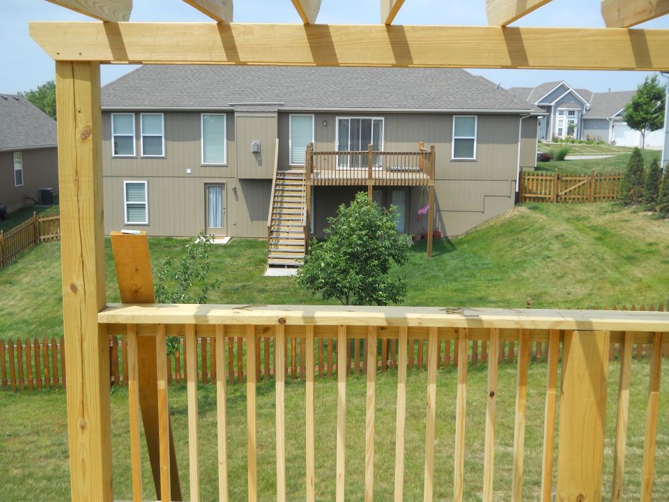 Backyard scene with wooden deck and house, Supermotors logo visible