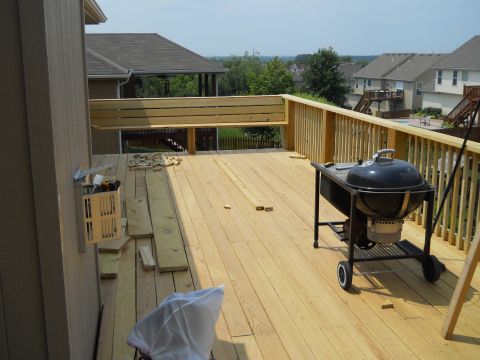 1976 Ford Bronco - Deck construction in progress, a grill and building materials. Suburban houses are in the distance.
