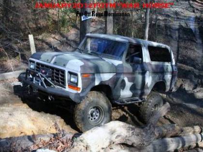 1979 Ford Bronco - This SUV is navigating a challenging off-road course with large rocks and dirt.