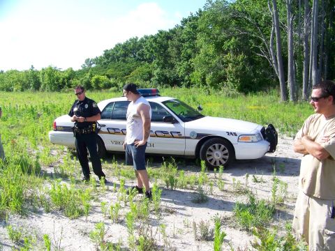 1985 Ford Bronco - Police car with 'Virginia Beach' text on the side is parked in a field.