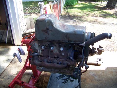 1985 Ford Bronco - This engine is mounted on a red stand, with various hoses and pipes attached.