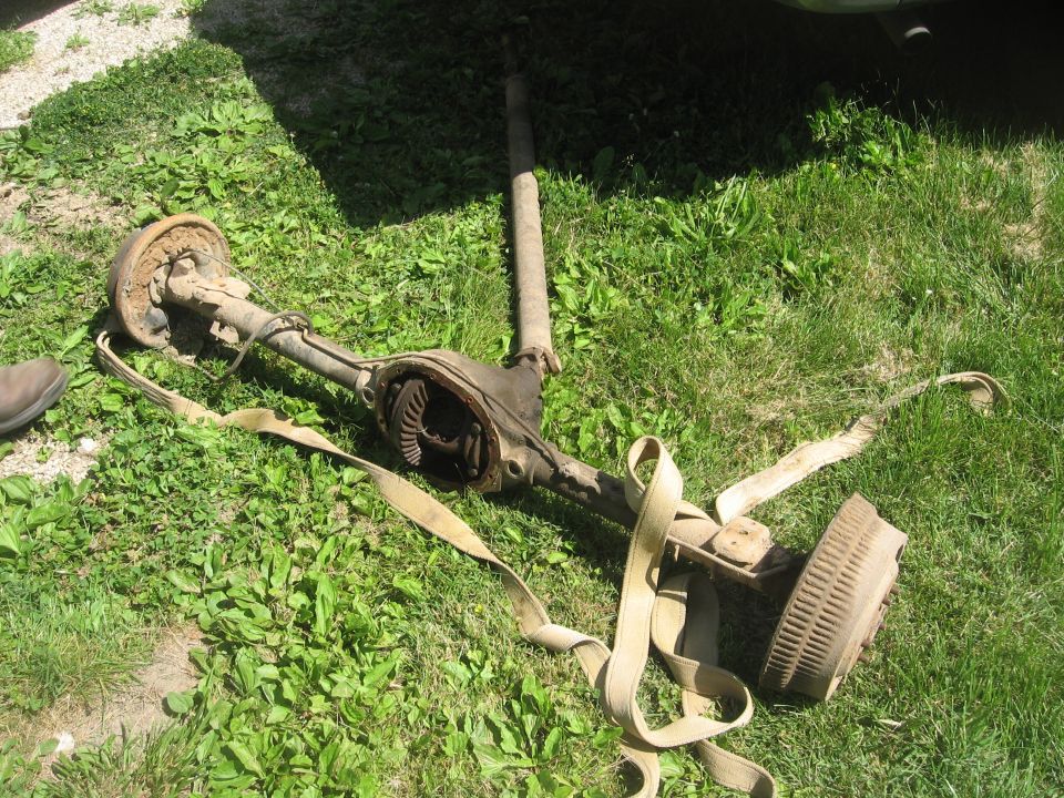 vehicle axle assembly with differential and brake drum lying on grass