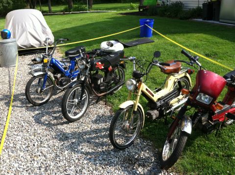 1981 Garelli Rally Sport - A collection of four mopeds are parked on a gravel driveway next to a grassy lawn.