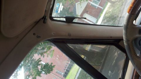 1994 Ford Bronco - Looking out from the driver's seat, the exterior shows a brick building and trees.