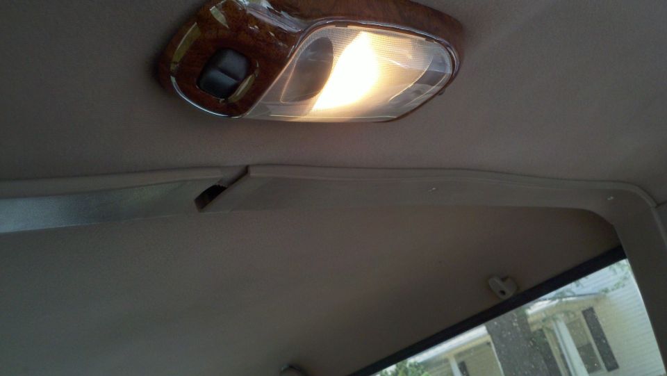 Interior ceiling light with wood trim and a cracked plastic trim piece