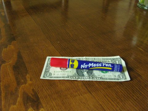 2007 Ford Mustang - WD-40 No-Mess Pen is placed on a dollar bill on a wooden table.