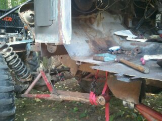 1978 Ford Bronco - Frame of a vehicle is being repaired with tools and parts laid out.