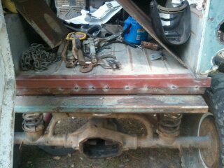 1978 Ford Bronco - The rear cargo area of a vehicle is shown, filled with various tools and parts, including chains and a blue container. A watermark for Supe…