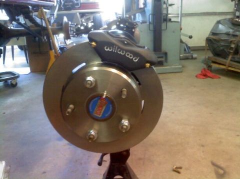 1988 Ford Bronco - A Wilwood brake caliper and rotor assembly is shown mounted on a stand in a workshop environment.