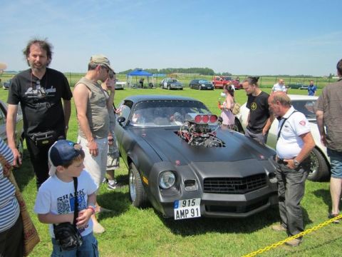 1991 Ford LTD Crown Victoria - A heavily modified 1981 Chevrolet Camaro with a prominent engine modification is displayed at an outdoor car show.