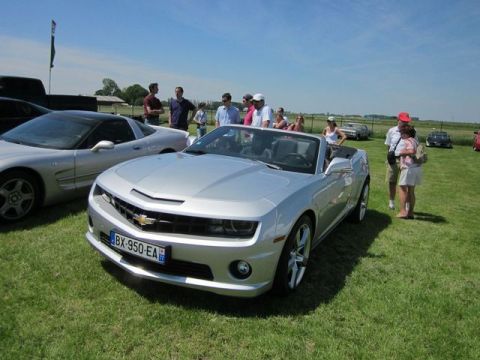 1991 Ford LTD Crown Victoria - A silver convertible Chevrolet Camaro is displayed outdoors with other vehicles and spectators.