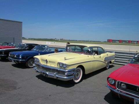 1991 Ford LTD Crown Victoria - A row of vintage cars are parked on asphalt under a clear blue sky.