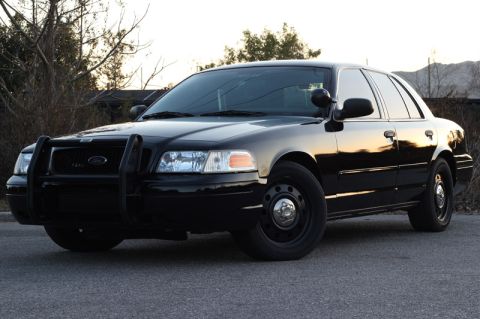 2004 Ford Crown Victoria - This black 2004 Ford Crown Victoria is viewed from a three-quarter front angle, showing its distinctive push bar.