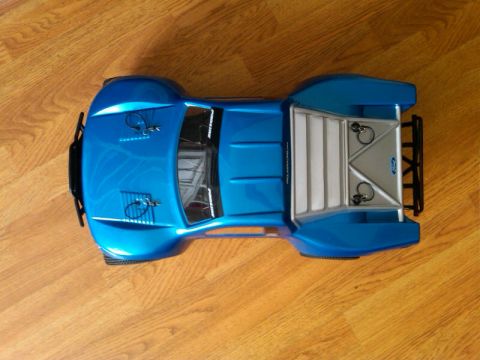 1986 Ford Bronco - Overhead view of a blue remote control truck body with silver accents on a wooden surface.