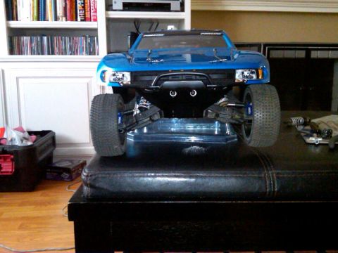 1986 Ford Bronco - A blue remote control truck is displayed on a black leather surface in front of a bookshelf.