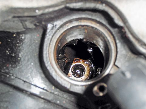 1990 Ford Bronco - Close-up view of a damaged distributor cap interior, showing a broken rotor and oily residue.