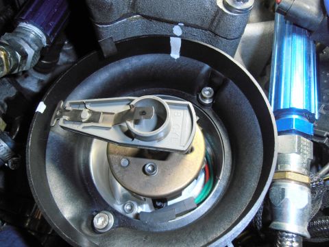 1990 Ford Bronco - Close-up of an engine distributor with cap removed, showing the rotor, internal pickup and blue ignition components nearby.