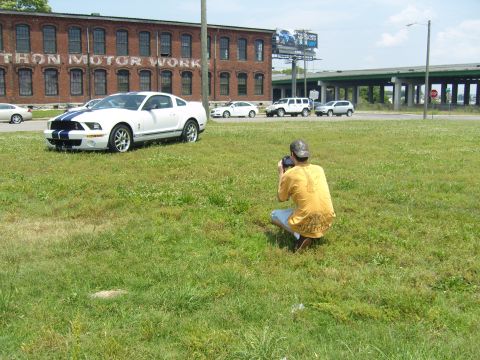 2007 Ford Mustang - Photographer captures a white 2007 Ford Mustang with blue stripes in an open field.