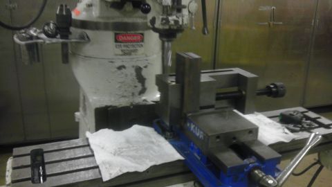 1989 Ford Bronco - A milling machine is set up with a vise mounted on its table, ready for operation.