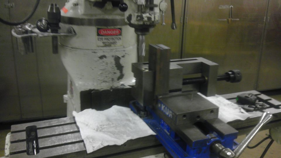 Milling machine with a blue vise attached to the table