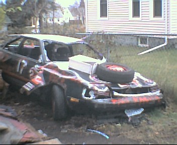 1980 Ford Bronco - This heavily damaged car has a spare tire strapped to its hood and appears to be used for demolition derby.