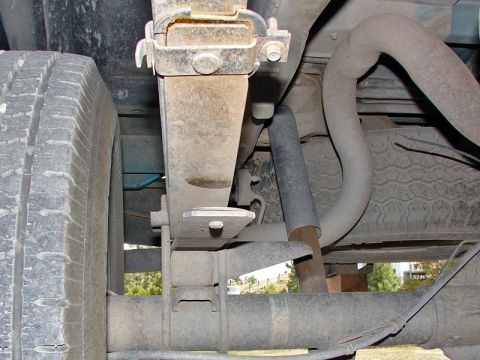 1998 Ford F-150 - Close-up view of the rear suspension components of a truck, including leaf springs and a shock absorber.