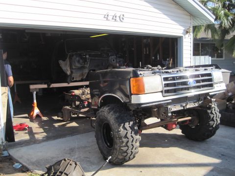 1989 Ford Bronco - Ford truck chassis undergoing work, front end shows grille and headlights.