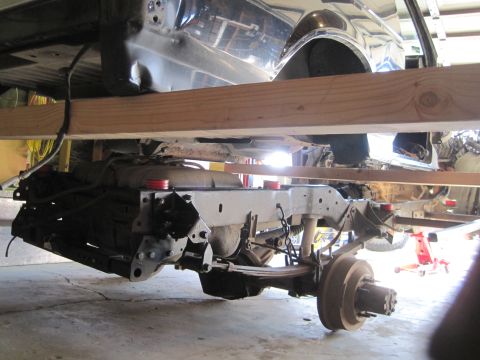 1989 Ford Bronco - Undercarriage of a vehicle undergoing repair, showing the frame and suspension components.