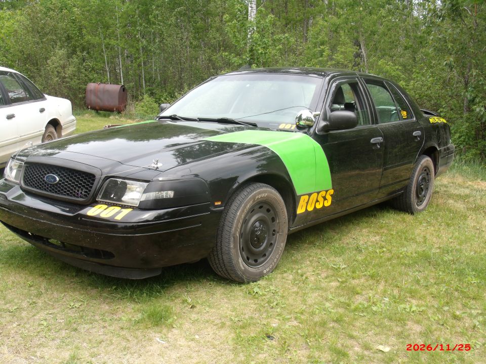Black 2003 Ford Crown Victoria with green stripe and yellow 'BOSS' text