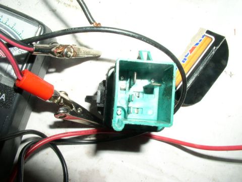 1990 Ford Bronco - Bench test of a green automotive relay/connector with multimeter and alligator clips, pencil for scale.