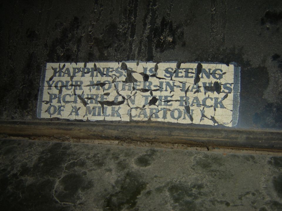 Cracked sign with text about mother-in-law and milk carton
