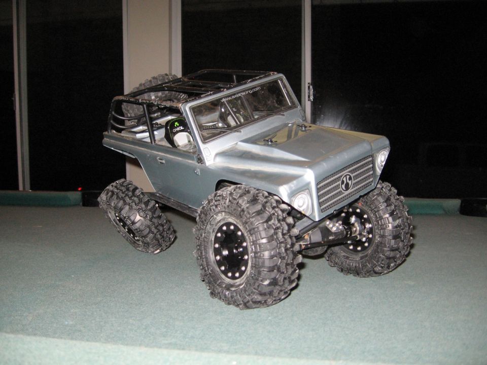 RC rock crawler with large tires and roll cage, silver body