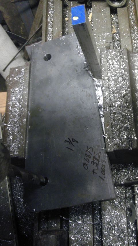 1989 Ford Bronco - A metal part is being worked on a milling machine, with measurements scribbled on its surface.