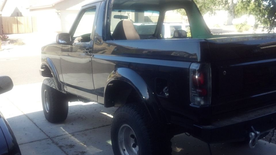 Black 1995 Ford Bronco with lifted suspension, rear quarter view
