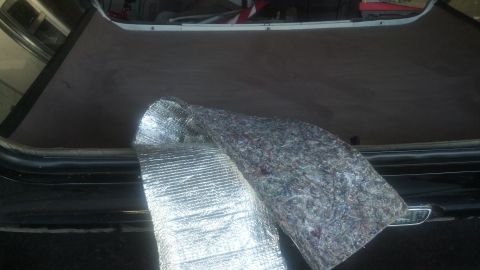 1995 Ford Bronco - Sound deadening material and insulation are laid out in the cargo area of a vehicle.