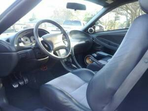 1982 Ford Bronco - Interior view of a car, showing the seats, steering wheel, and dashboard with a prominent "SUPERMOTORS" logo.