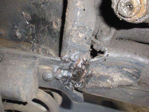 1988 Ford F-250 - Close-up of a heavily modified vehicle frame, showing extensive welding and corrosion.