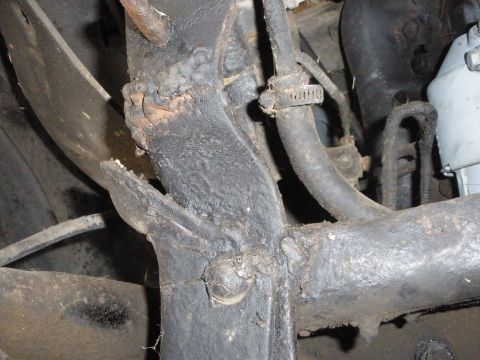 1988 Ford F-250 - Detail of a vehicle's undercarriage, showing the frame and attached hoses, with visible rust and wear.