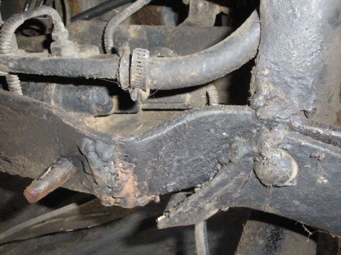 1988 Ford F-250 - Detail of a truck frame showing a hose and clamp, likely from the underside.