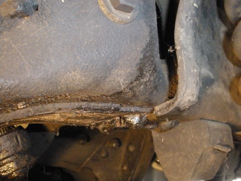1988 Ford F-250 - A detailed view of heavily soiled and aged vehicle frame components, showing signs of wear and tear.