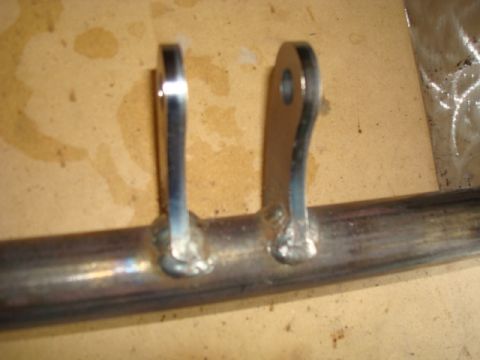 1995 Ford Bronco - Close-up of welded metal brackets attached to a pipe.