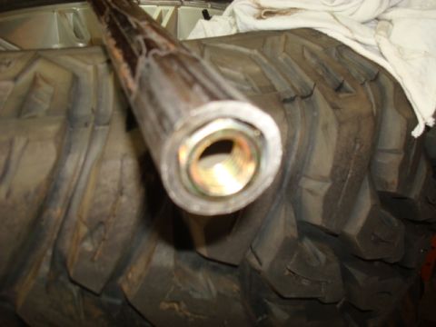 1995 Ford Bronco - Close-up of a vehicle axle part and tire tread.