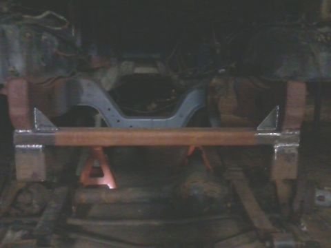 1985 Ford Bronco - A custom-fabricated crossmember is supported by jack stands, likely for a vehicle suspension modification.