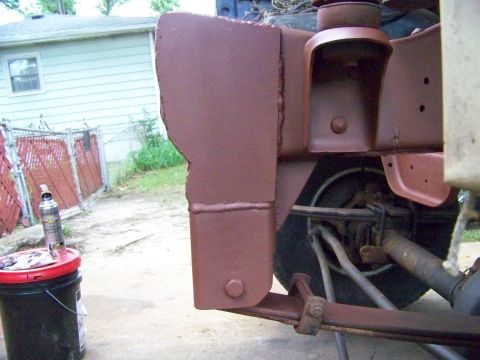 1985 Ford Bronco - Close-up view of vehicle frame and suspension components, showing signs of rust and recent paint application.