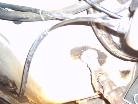 1991 Ford LTD Crown Victoria - Close-up view of hoses and a mechanical linkage within a vehicle's engine bay.