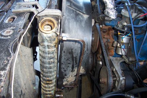 1980 Ford Bronco - Engine-bay view down the passenger side of the radiator with the cap removed, showing the crusty, scaled filler neck and side tank plus the…